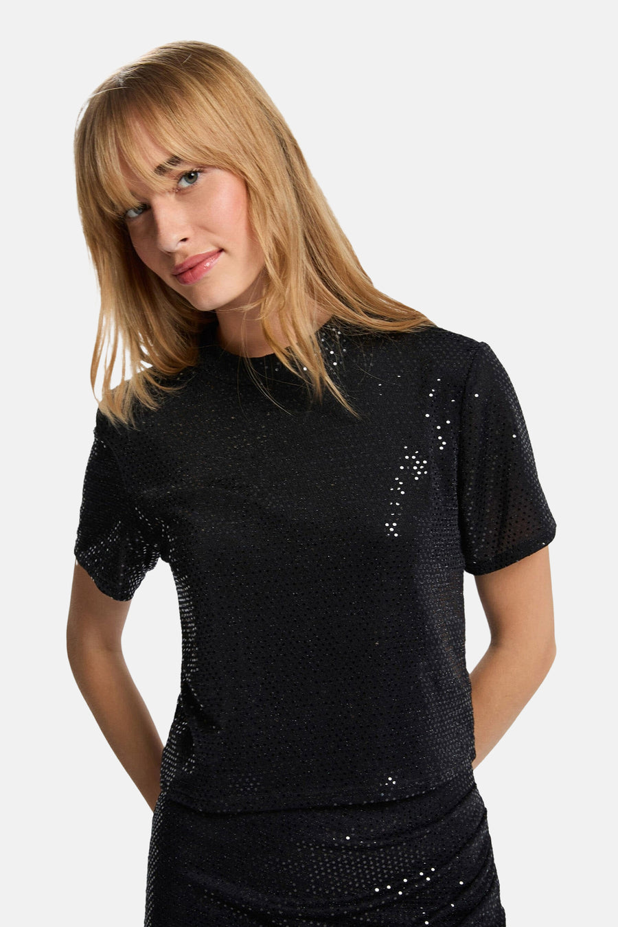 Zwart T-shirt met korte mouwen van Morgan de Toi, versierd met glinsterende pailletten, gedragen met een bijpassende rok.