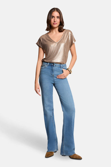 Gouden T-shirt met korte mouwen van Morgan de Toi, gedragen met een uitlopende jeans en bruine enkellaarsjes.