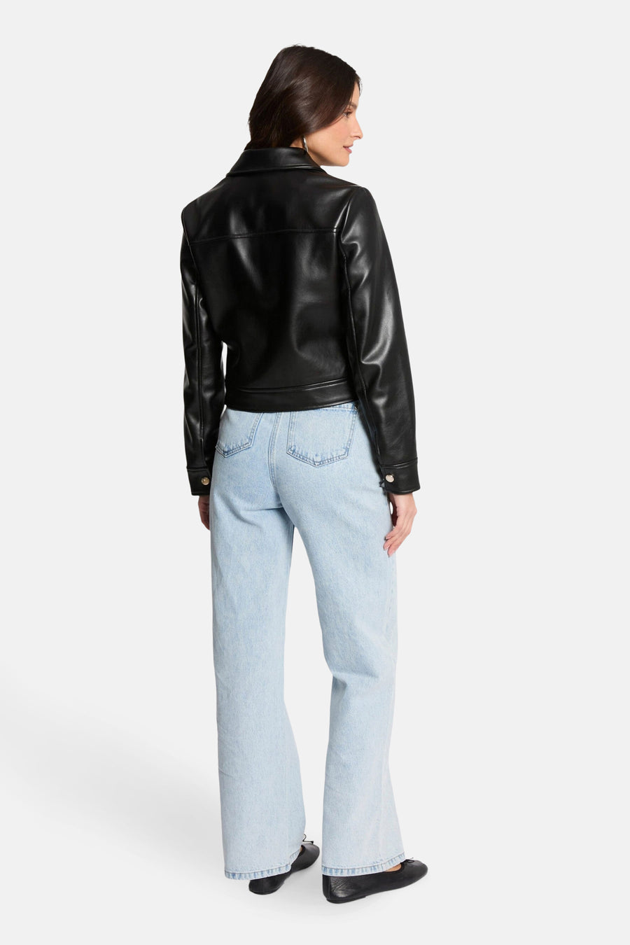 Zwarte leren jas van Morgan de Toi, met gouden details, gedragen met een high-waisted jeans.