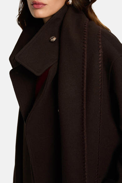 Long manteau brun de Morgan de Toi avec détails de surpiqûres décoratives et bouton orné au col.