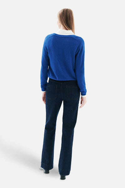 Blauwe cardigan van CAROLL, gedragen met een witte blouse en donkere jeans, achterzicht.