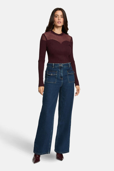 Bordeaux ribbelpull van Morgan de Toi, met gestreept schouderstuk en gedragen met een high-waisted jeans.
