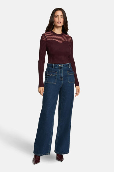 Bordeaux ribbelpull van Morgan de Toi, met gestreept schouderstuk en gedragen met een high-waisted jeans.