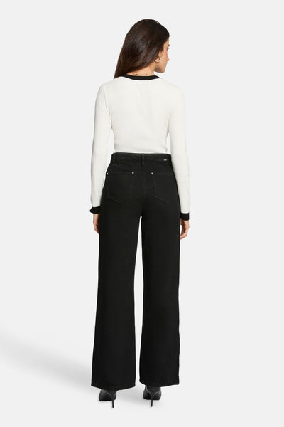 Witte V-hals trui van Morgan de Toi, lange mouwen, gedragen met een zwarte broek met hoge taille.
