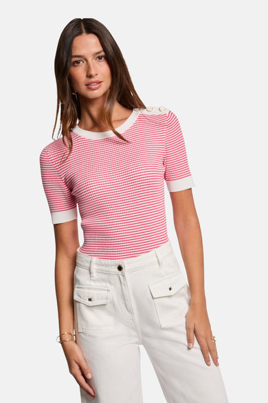 Roze gestreepte trui van Morgan de Toi, met knoopdetails op de schouders en gedragen met een witte broek.