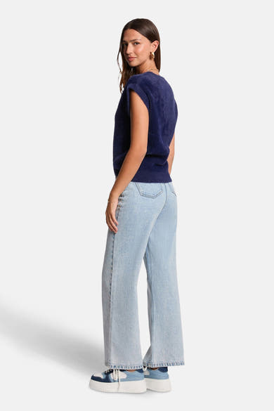 Blauwe tanktop van Morgan de Toi, gedragen met wijde jeans en plateauzolen, achterzicht.