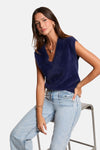 Blauwe, pluizige gebreide tanktop van Morgan de Toi, gedragen met een high-waisted jeans en gouden sieraden.