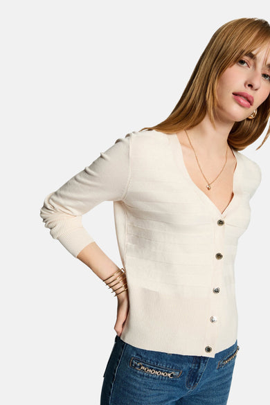 Ecru vest van Morgan de Toi, met zilveren knopen, gedragen met een blauwe jeans en gouden armbanden.