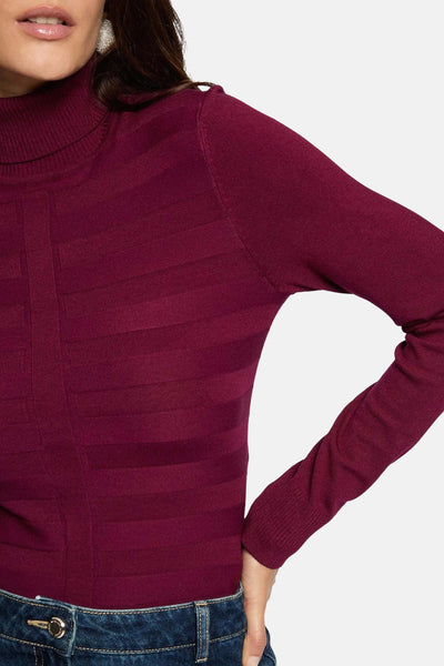 Pull à col roulé bordeaux de Morgan de Toi avec motif à rayures horizontales, porté avec un jean bleu.
