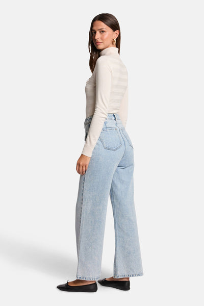 Ecru coltrui van Morgan de Toi, met doorschijnende horizontale strepen, gedragen met een wijde jeans en zwarte ballerina's.