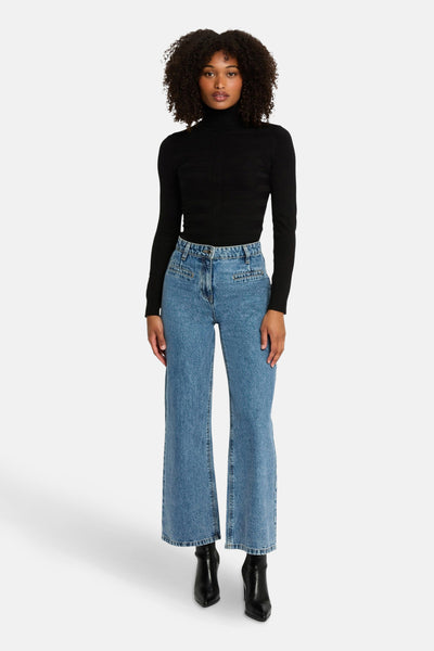Zwarte coltrui van Morgan de Toi, gedragen met een high-waist jeans en zwarte enkellaarsjes.
