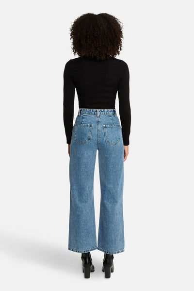 Zwarte coltrui van Morgan de Toi, gedragen met een blauwe high-waist jeans en zwarte leren enkellaarsjes.