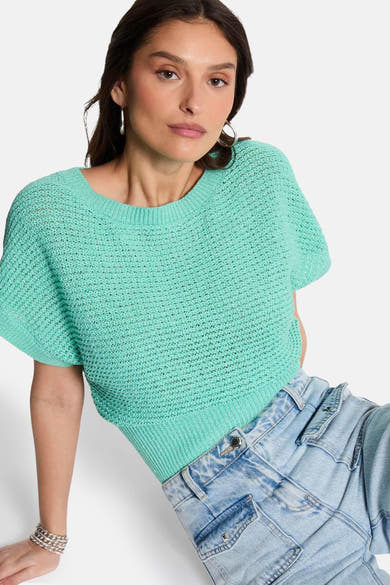 Groene trui met ronde hals van Morgan de Toi, in ajourgebreide stof, gedragen met een casual spijkerbroek.