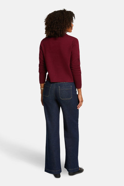 Rode Morgan de Toi-cardigan, gedragen met een spijkerbroek en ballerina's, achtergezicht.