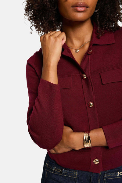 Cardigan rouge en maille par Morgan de Toi, avec boutons dorés, poches plaquées et bracelet doré.
