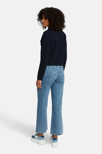 Marineblauwe cardigan van Morgan de Toi, gedragen met een high-waisted jeans en plateauzolen.