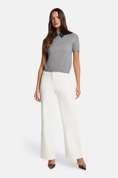 Grey short-sleeve O-neck sweater with denim collar, worn with white wide-leg pants and burgundy heels, full-length front view