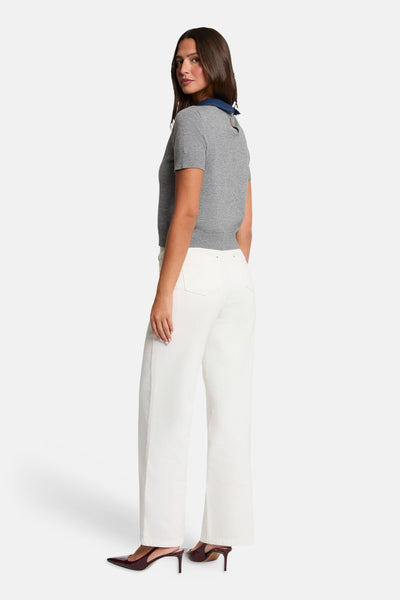 Grey short-sleeve O-neck sweater with ribbed cuffs and hem, side view on model wearing white wide-leg pants and burgundy heels