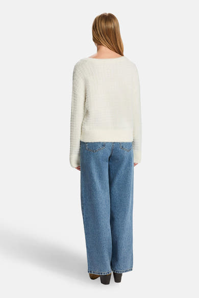 Pull en maille blanc by Morgan de Toi, porté avec un jean ample bleu et des bottines marron, vue de dos.
