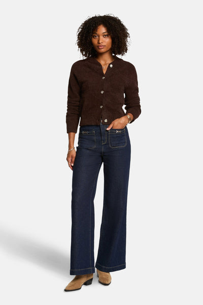 Bruine cardigan van Morgan de Toi, gedragen met een high-waisted flared jeans en suède enkellaarsjes.