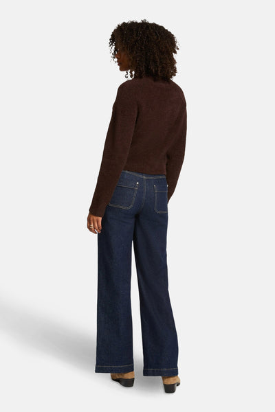 Bruine, pluizige gebreide cardigan van Morgan de Toi, gedragen met een wijde jeans en enkellaarsjes met hak.
