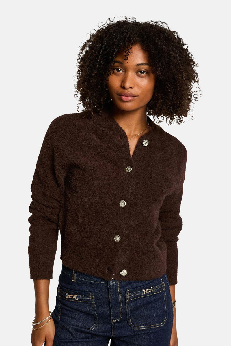 Morgan de Toi donzig bruin vest met zilveren knopen, gedragen met een high-waist jeans.