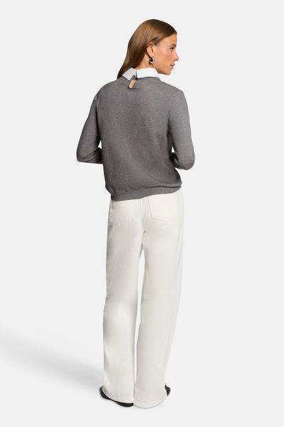 Grijze coltrui van Morgan de Toi, gedragen met een wit overhemd en een witte broek.