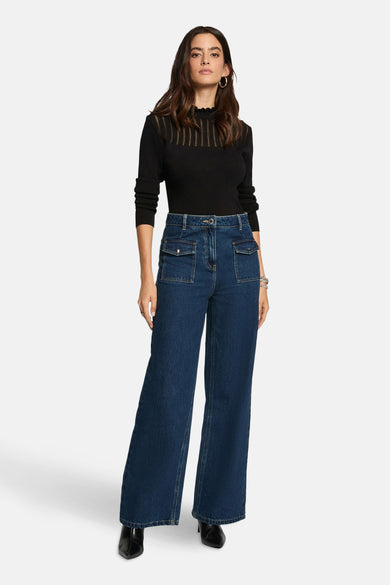 Pull à col rond noir de Morgan de Toi avec détails ajourés et porté avec un pantalon en jean taille haute.
