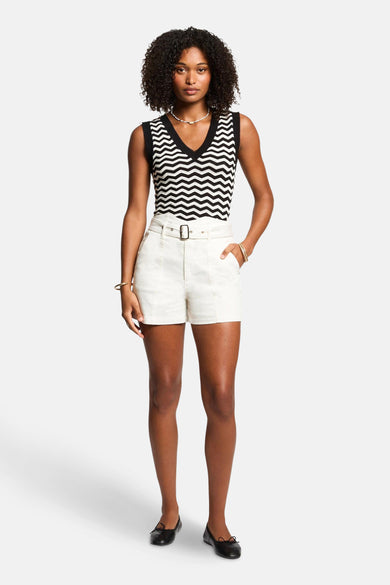 Zwart-wit mouwloze top met zigzagpatroon van Morgan de Toi, gedragen met een short met hoge taille.