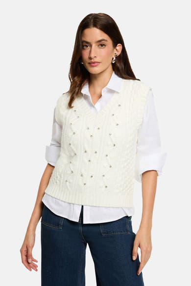 Witte mouwloze top van Morgan de Toi in gevlochten breiwerk, gedragen met een wit overhemd en een wijde donkerblauwe jeans.