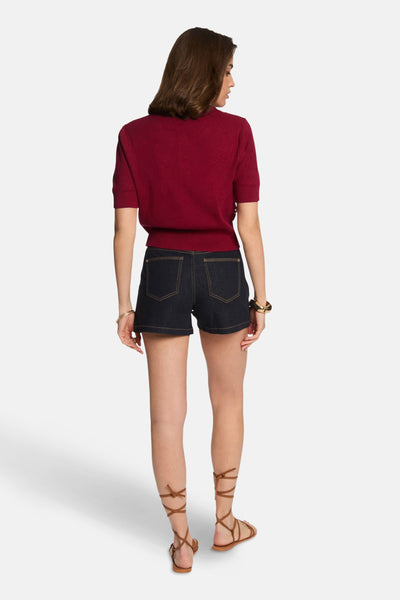 Rode rondehals-trui van Morgan de Toi gedragen met een donkerblauwe spijkerbroekshort en vetersandalen.