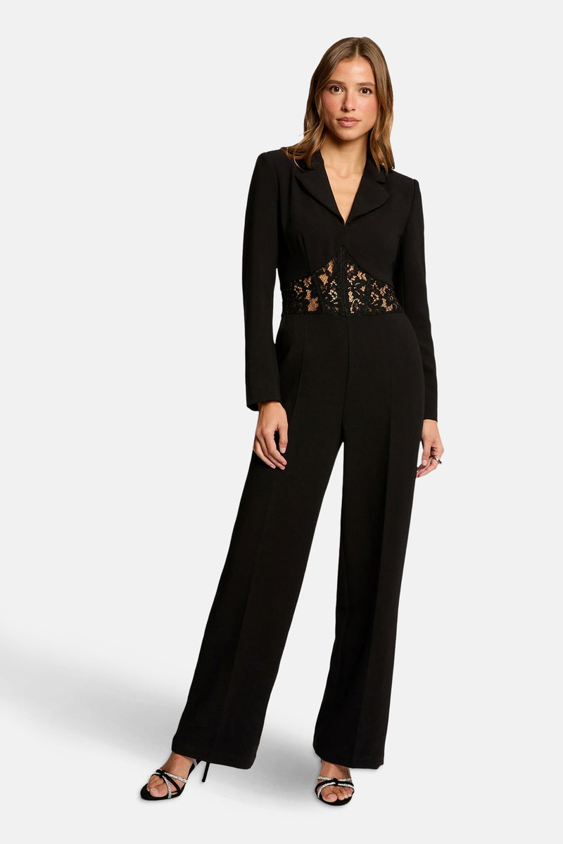 Zwarte jumpsuit van Morgan de Toi, met een bloemenkanten riem aan de voorkant.