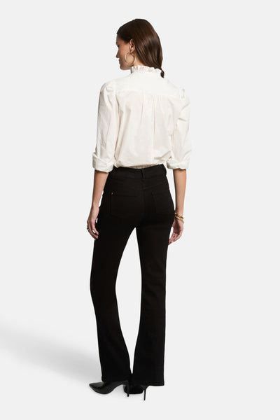 Zwarte bootcut jeans van Morgan de Toi, gedragen met een wit overhemd en zwarte hakken.