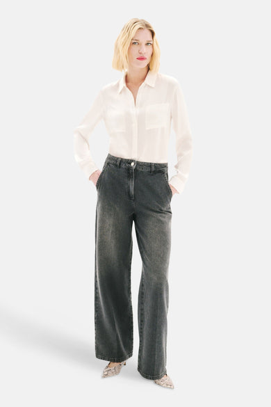 Grijze wijde jeans van CAROLL, gedragen met een wit overhemd en slangenprint pumps.