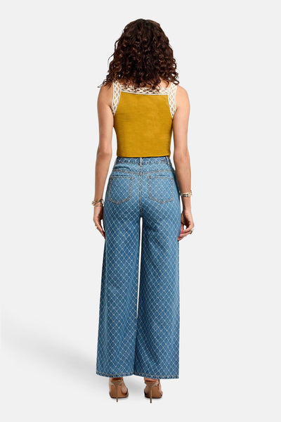 Pantalon en denim bleu moyen de Morgan de Toi, avec motif géométrique et chaussures à talons hauts.
