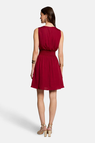 Robe bordeaux de Morgan de Toi avec taille élastique, longueur au-dessus du genou et sandales dorées.