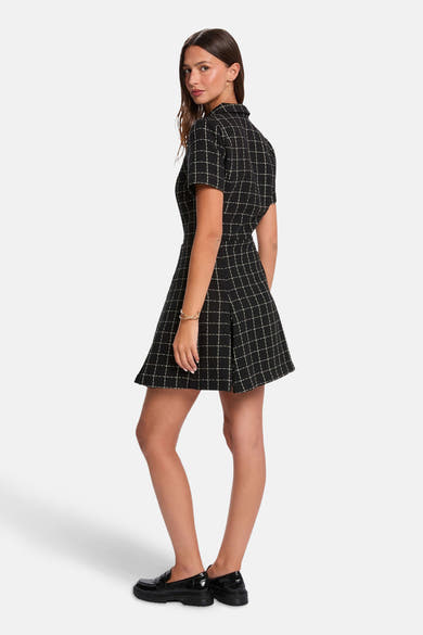 Robe noire à carreaux par Morgan de Toi, avec manches courtes et coupe évasée.