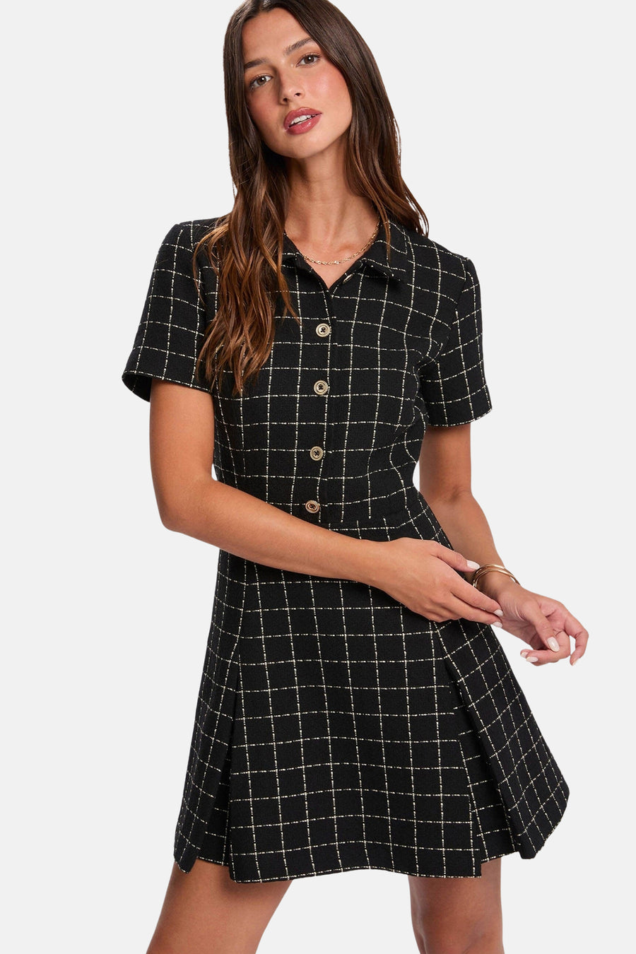 Robe noire à carreaux à manches courtes par Morgan de Toi, avec col, boutons dorés et ourlet plissé.