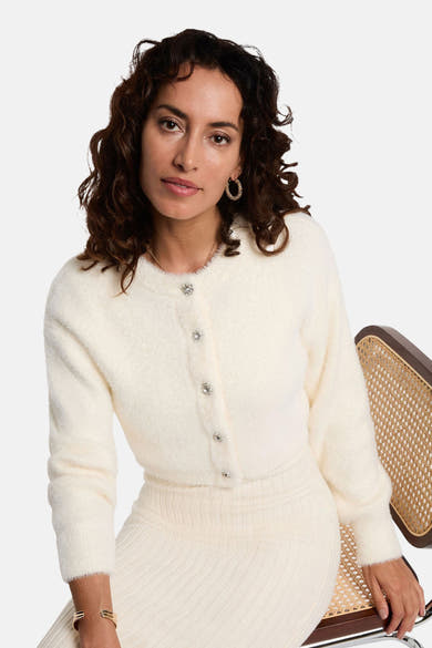 Robe à manches longues écru de Morgan de Toi avec un cardigan boutonné et des bijoux dorés.
