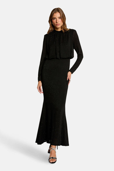 Robe noire à manches longues de Morgan de Toi, coupe sirène avec détails scintillants et chaussures à talons ornées.