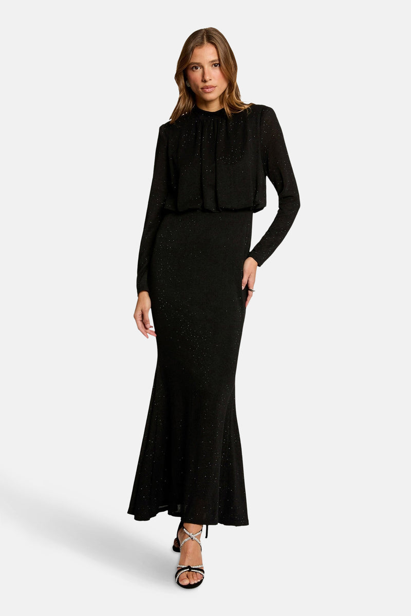 Robe noire à manches longues de Morgan de Toi, coupe sirène avec détails scintillants et chaussures à talons ornées.