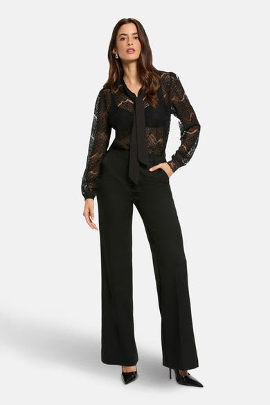 Zwarte blouse met lange mouwen van Morgan de Toi met kantpatroon, gedragen met een zwarte pantalon met hoge taille.
