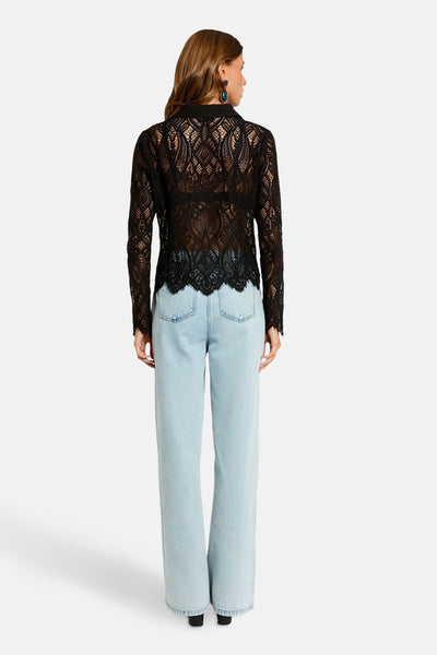 Zwarte kanten blouse van Morgan de Toi, gedragen met een high-waisted jeans.