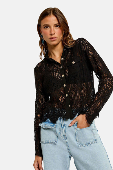 Zwarte blouse met lange mouwen van Morgan de Toi, van doorschijnend kant met gouden knopen, gedragen met een casual spijkerbroek.
