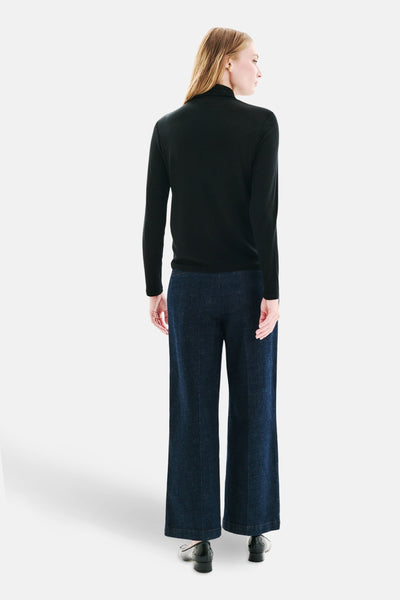 T-shirt à manches longues noir de CAROLL, porté avec un pantalon évasé en denim, vue de dos.