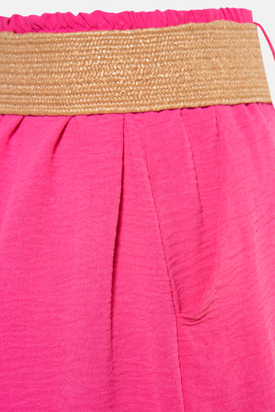 Short rose de Terra di Siena, avec ceinture tressée contrastante et poches latérales.