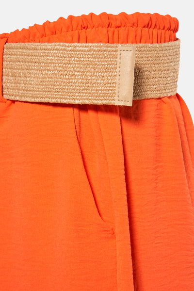 Korte oranje jurk van Terra di Siena met gevlochten riem, zijzak en gekreukte textuur.