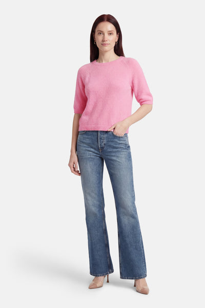 Pull à col rond rose de Terra di Siena avec manches courtes et coupe décontractée, porté avec un jean taille haute.