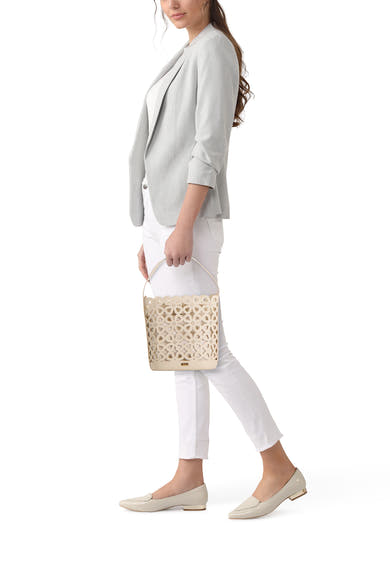 Sac à main beige de Morgan de Toi avec motif fleuri découpé, tenu par une femme en blazer gris.