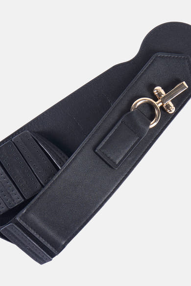 Zwarte riem van Morgan de Toi, met gouden gesp en geperforeerde details, op lichte achtergrond.